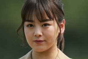 女性がクロージングブレザーを着て、屋外でポートレートを撮影しています。仕事の制服のようです。