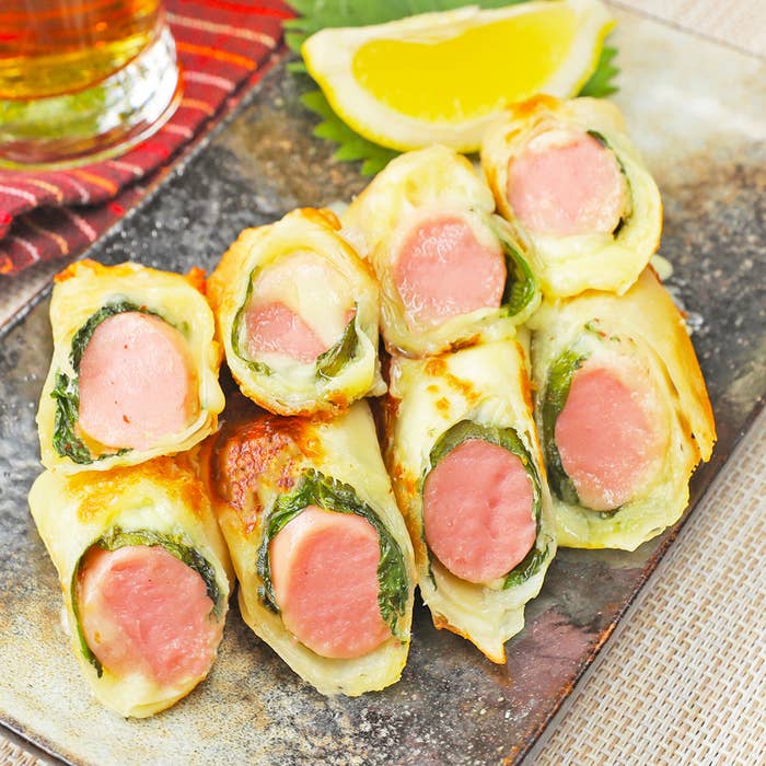 ソーセージがキャベツや生地に包まれた料理が皿に盛られています。