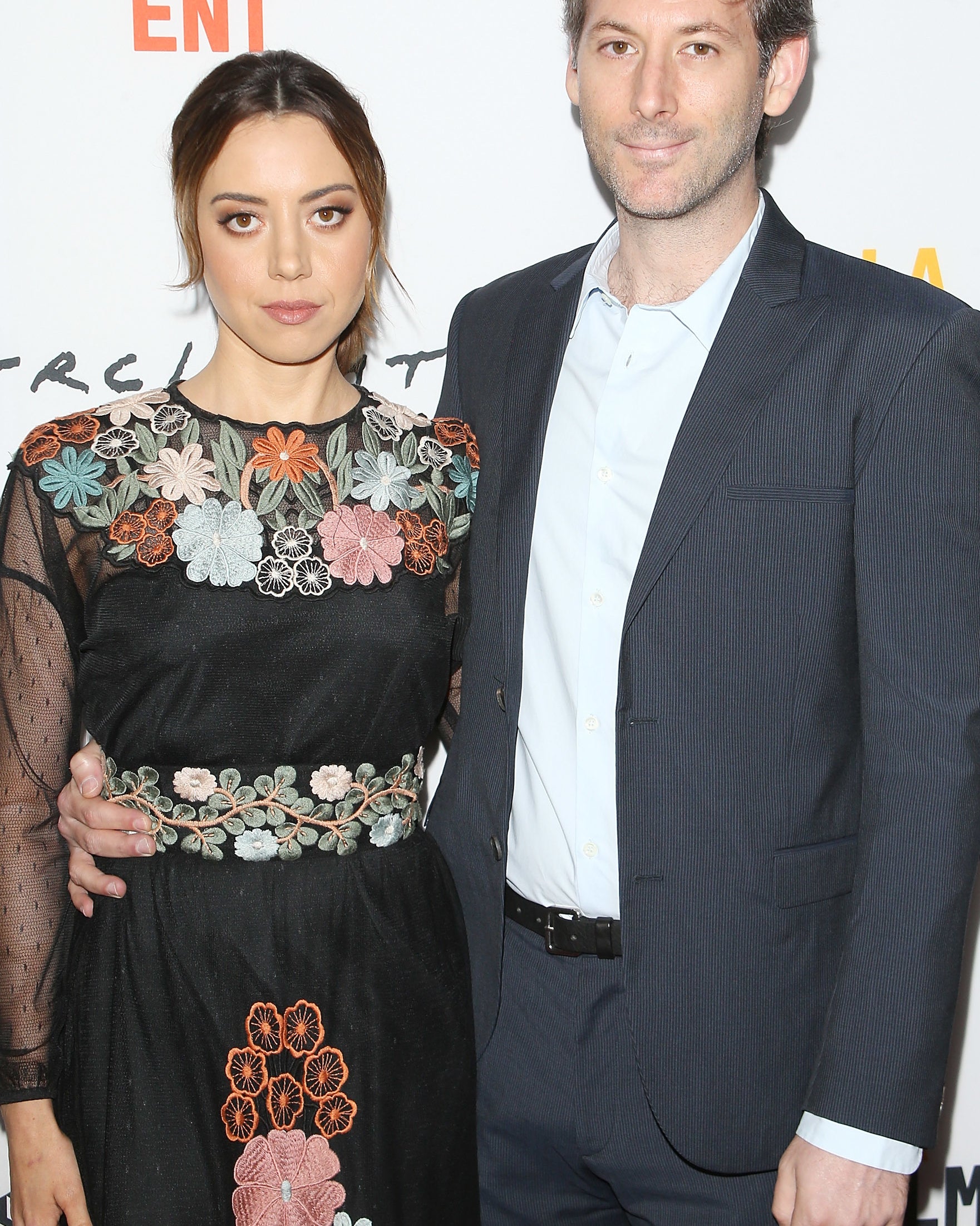 Jeff and Aubrey standing together at a film festival event, Aubrey wearing a floral dress, Jeff in a suit