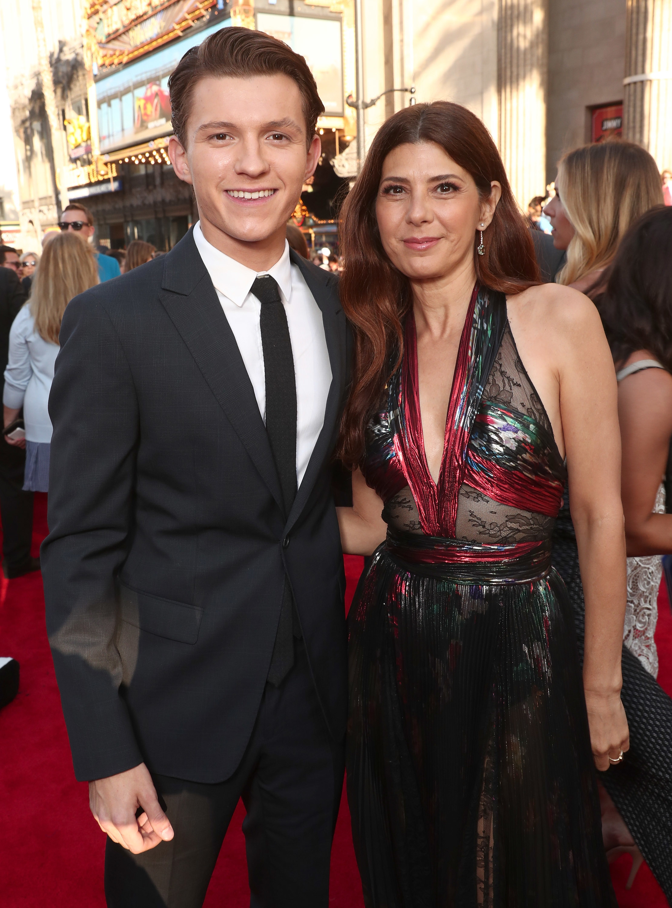 Tom Holland and Marisa Tomei pose on a red carpet