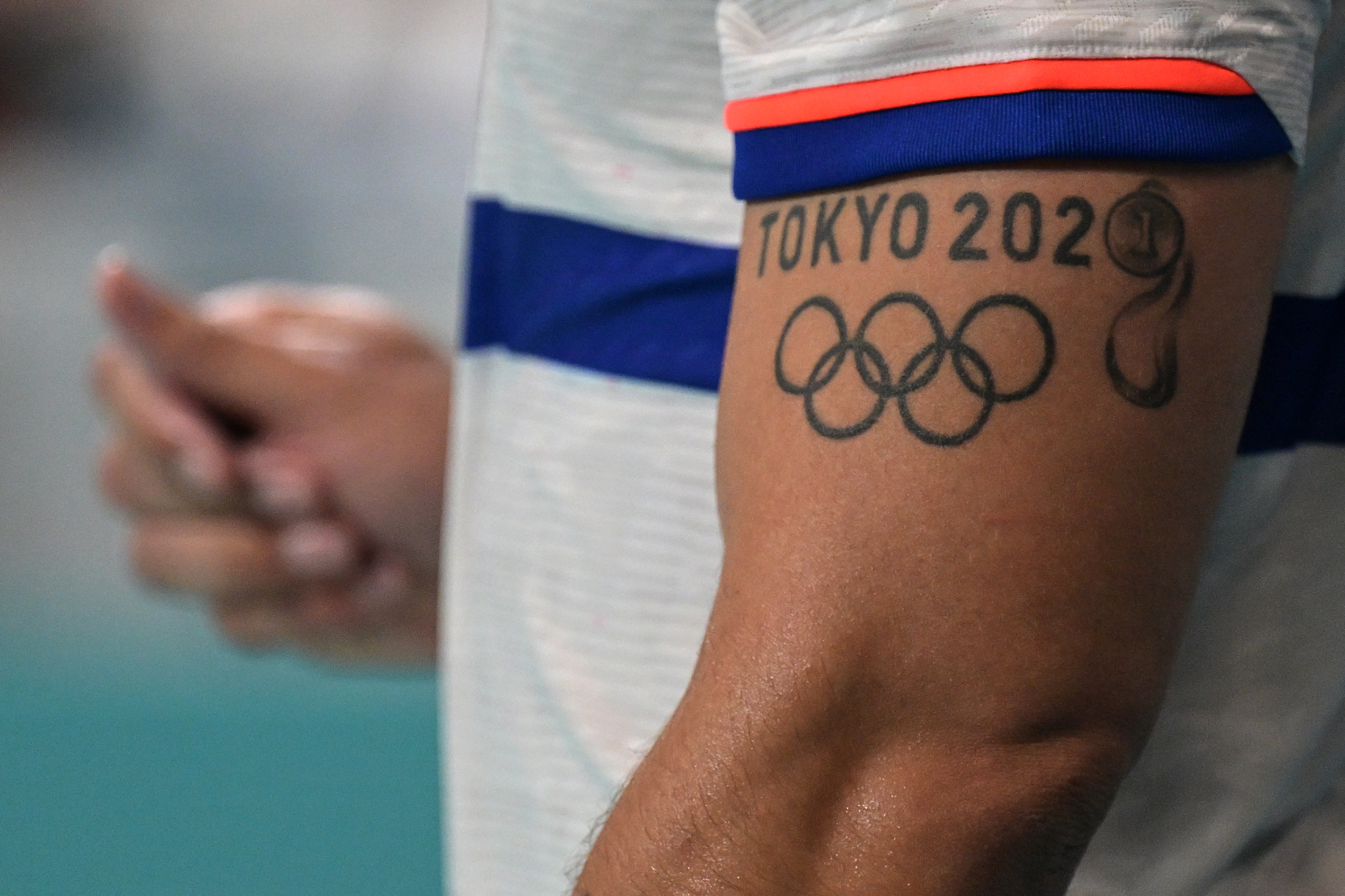 Arm with a tattoo of the Tokyo 2020 Olympics logo and symbols