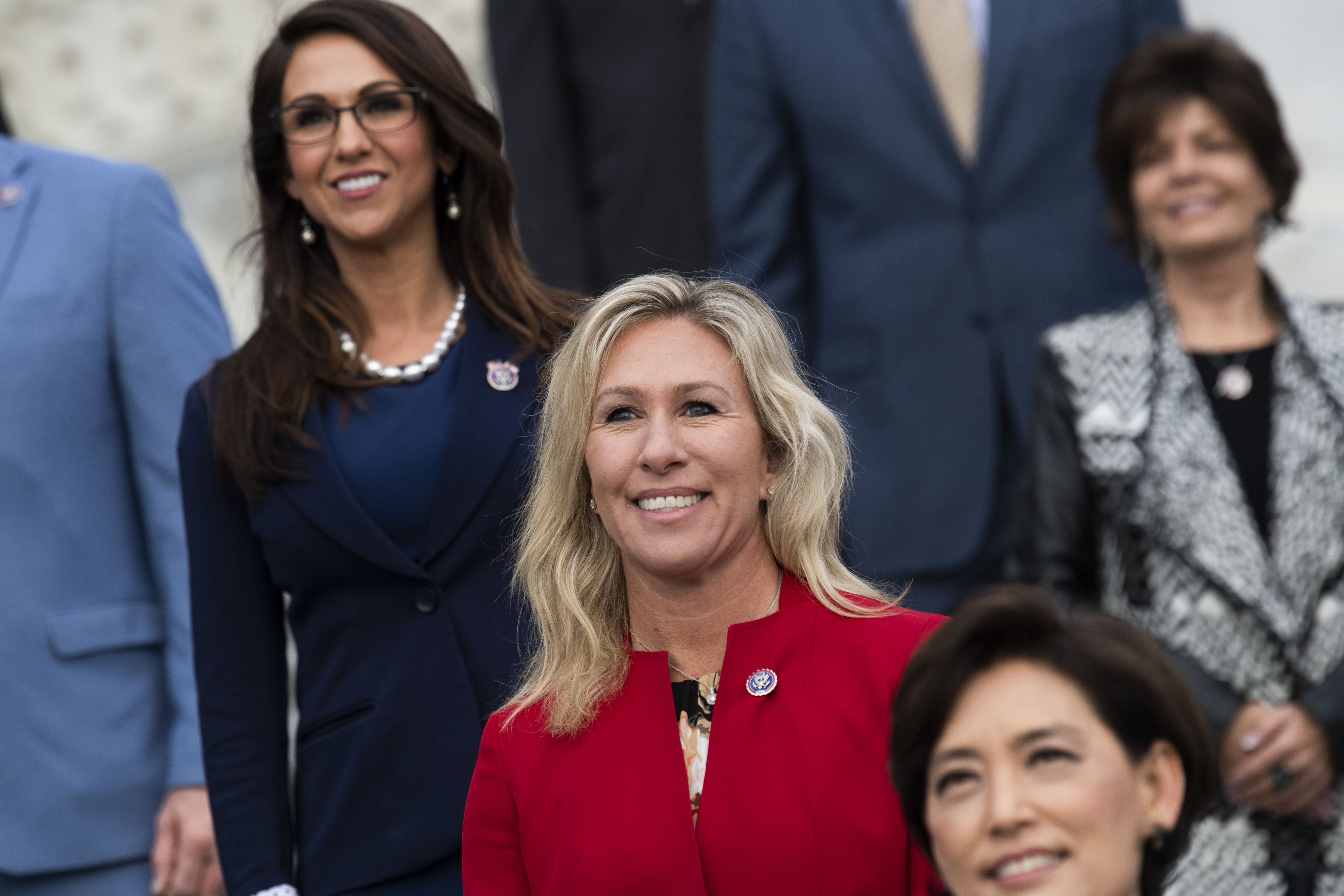 Group of people in formal attire posing for a photo at a public event