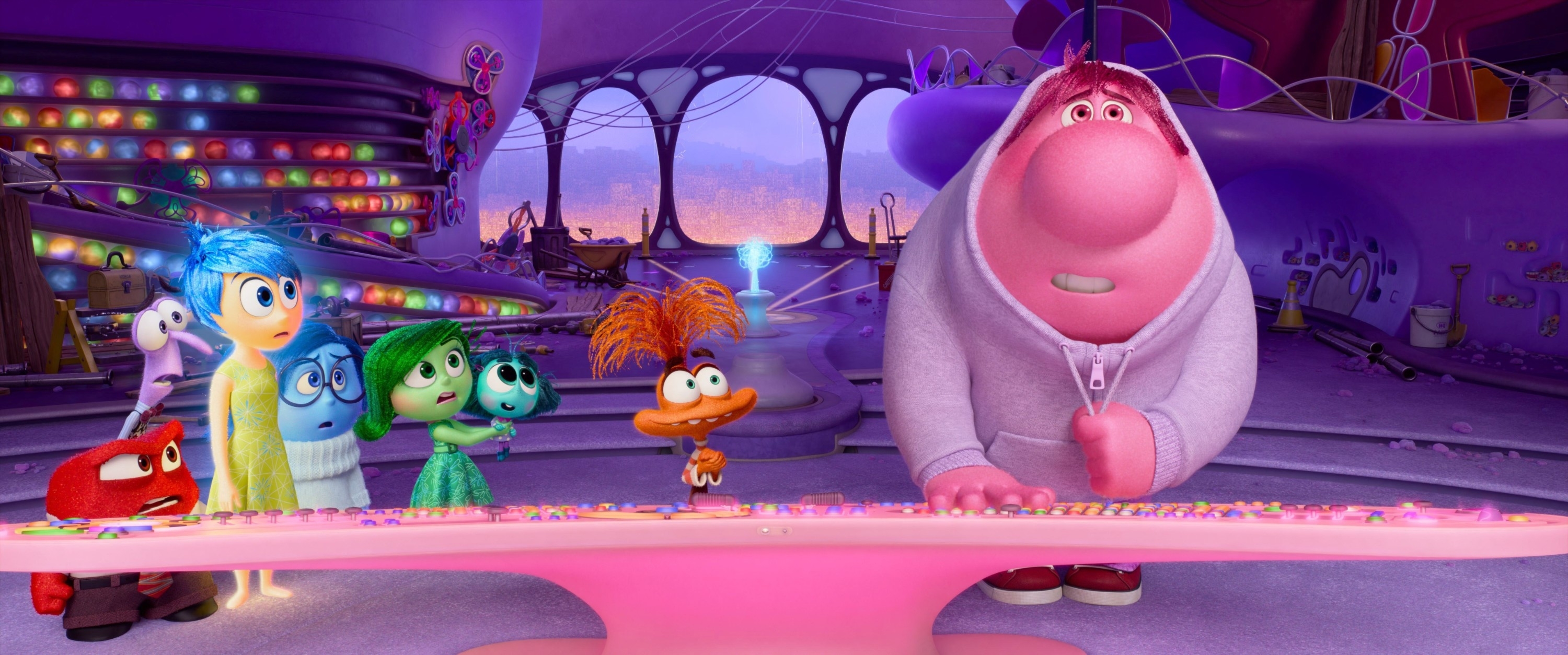 Animated characters from &quot;Inside Out&quot; stand together in a colorful control room, portraying various emotions with unique expressions and features