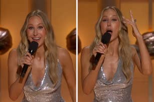 Person on stage wearing a sparkling dress, holding a microphone, gesturing expressively while speaking