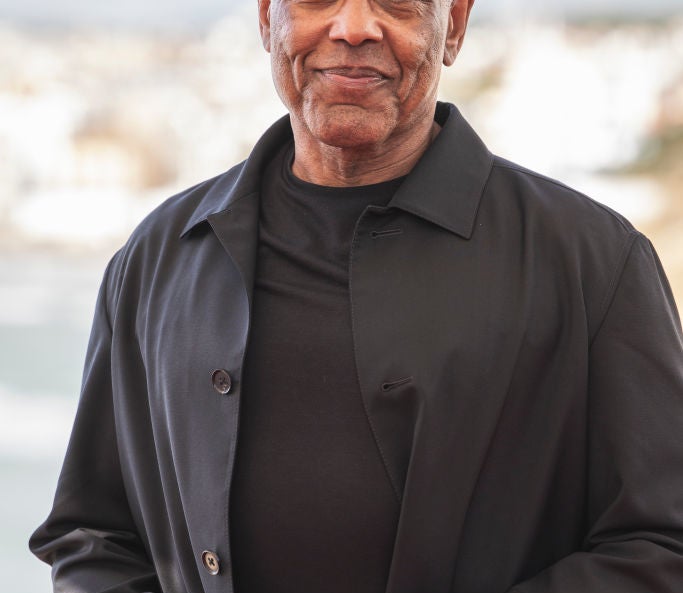 Giancarlo Esposito in a dark shirt and coat at an outdoor event