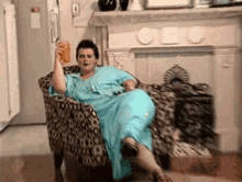 Person lounging in an armchair, sipping a drink, wearing a loose, stylish outfit with short hair, inside a home