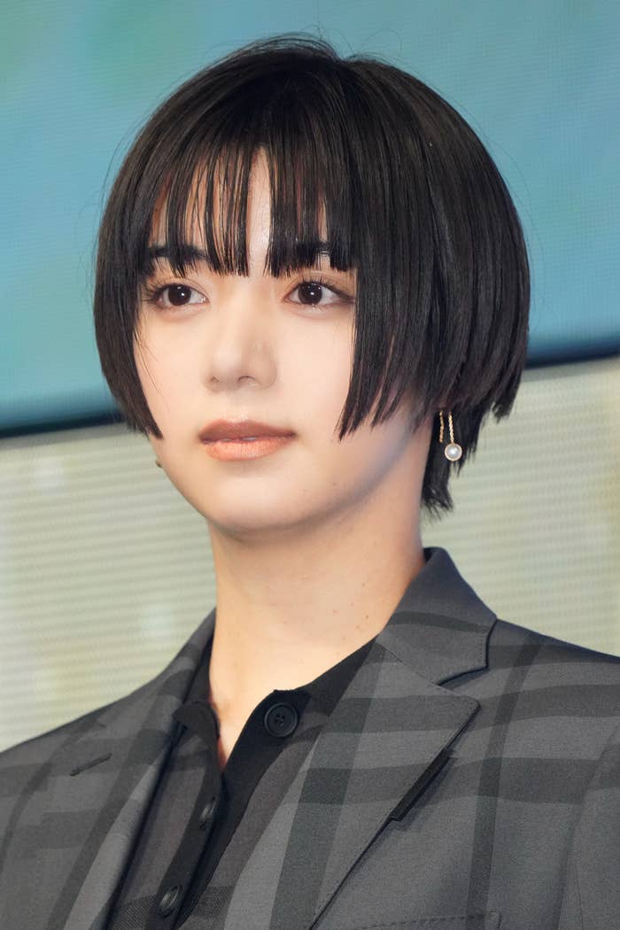人物がチェック柄のジャケットを着ているポートレート写真。髪はショートスタイル。