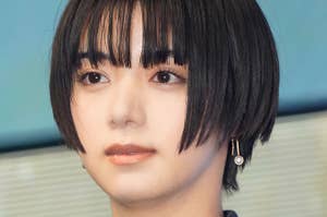 ショートヘアの人物がグレーのチェック柄ジャケットを着ている。