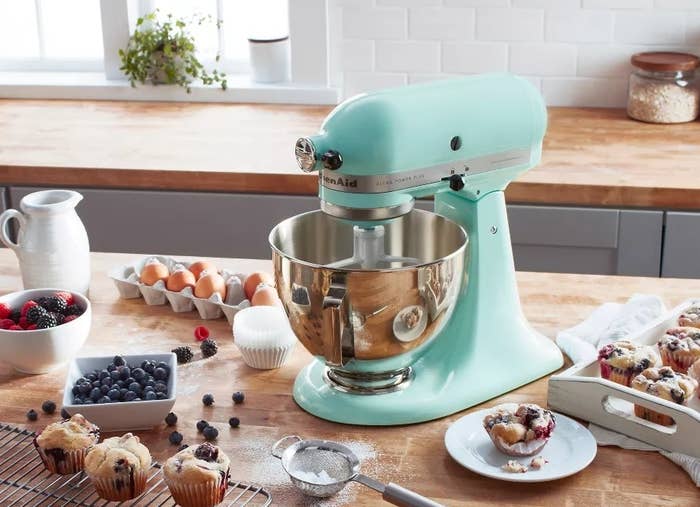 KitchenAid basal mixer connected a antagonistic with berries, muffins, and baking ingredients nearby