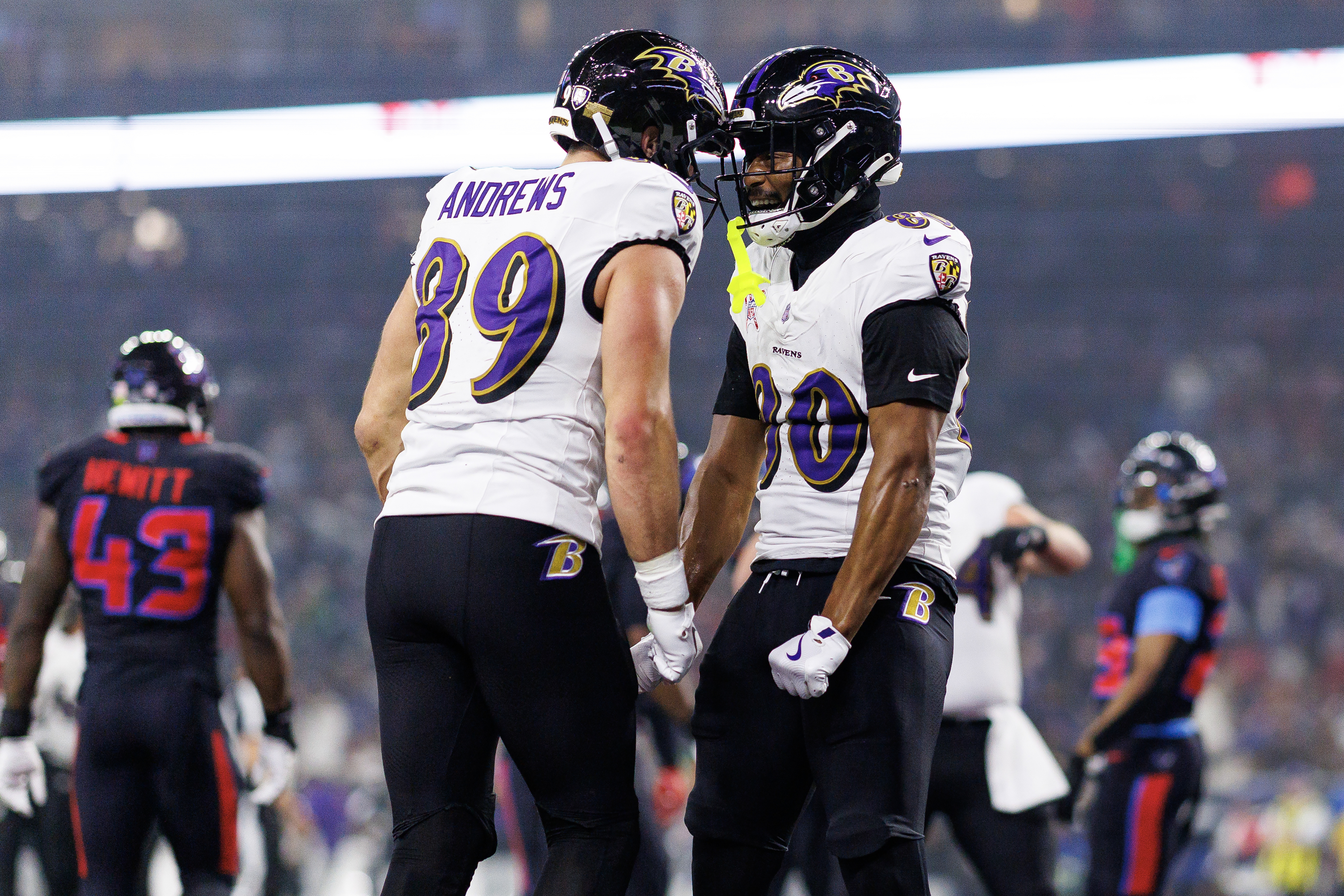 Two Baltimore Ravens players celebrate on the field during a game