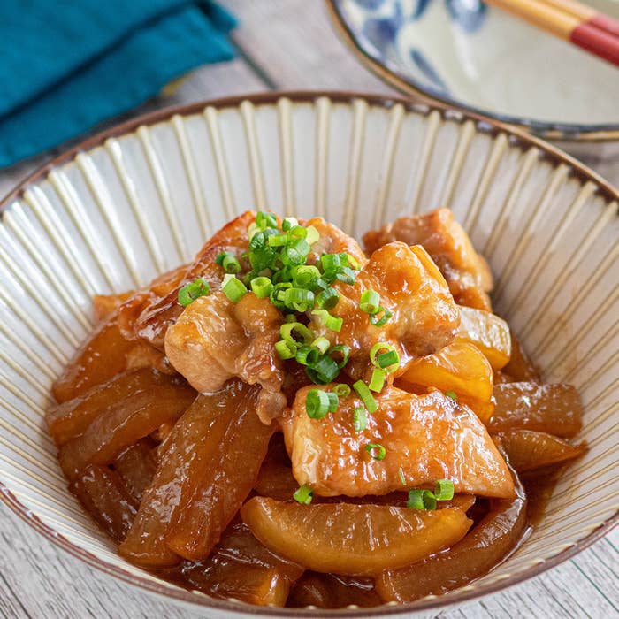 器に盛られた豚肉と大根の煮物、ネギがトッピングされている。