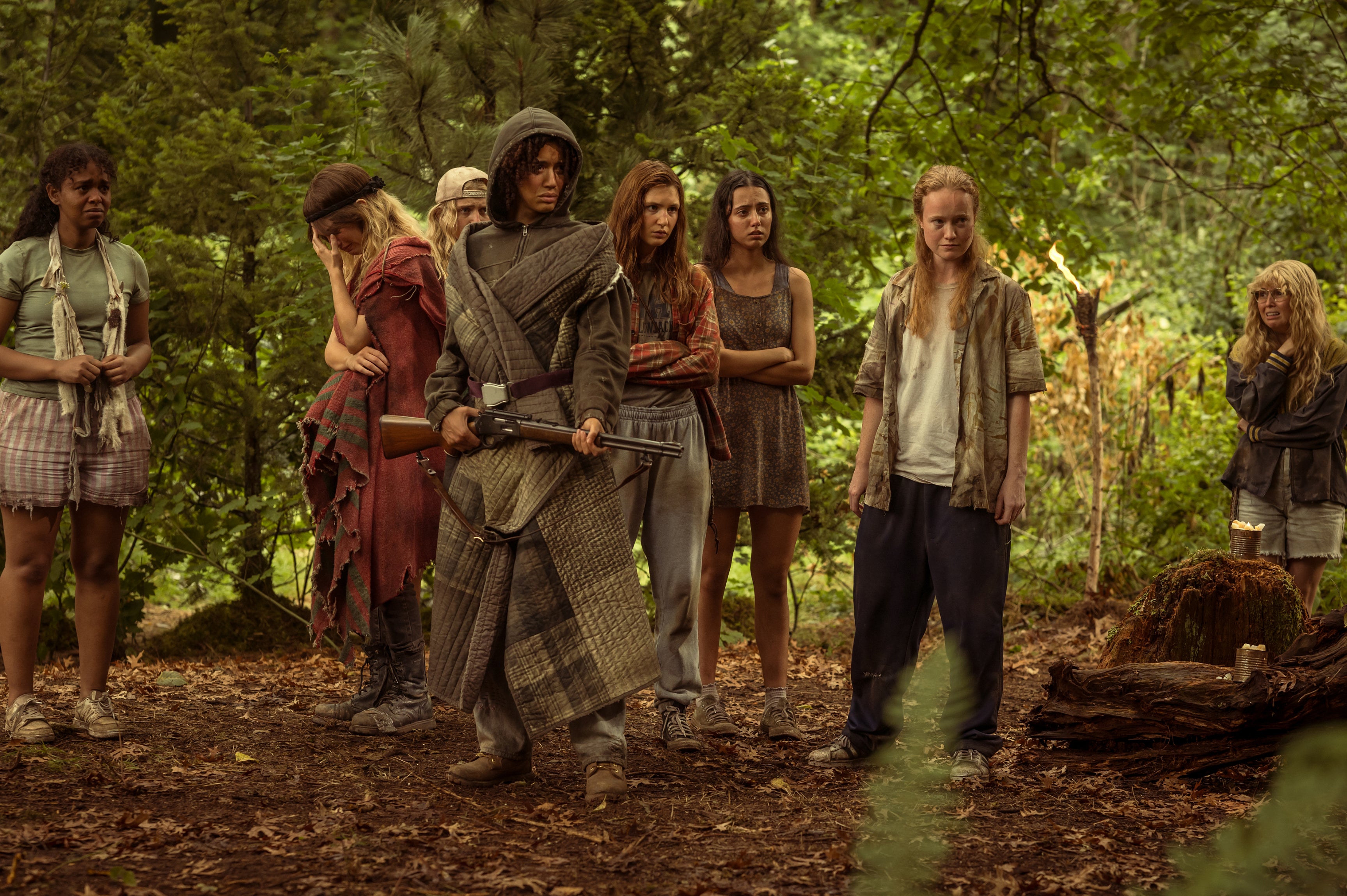 A scene from "Yellowjackets" Season 3 with the teenager girls in the woods looking intimidating