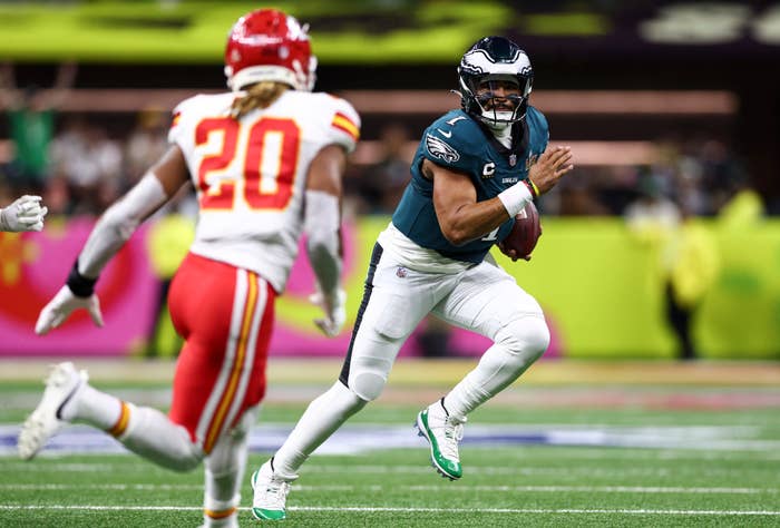 Eagles football player running with the ball, pursued by a Chiefs player
