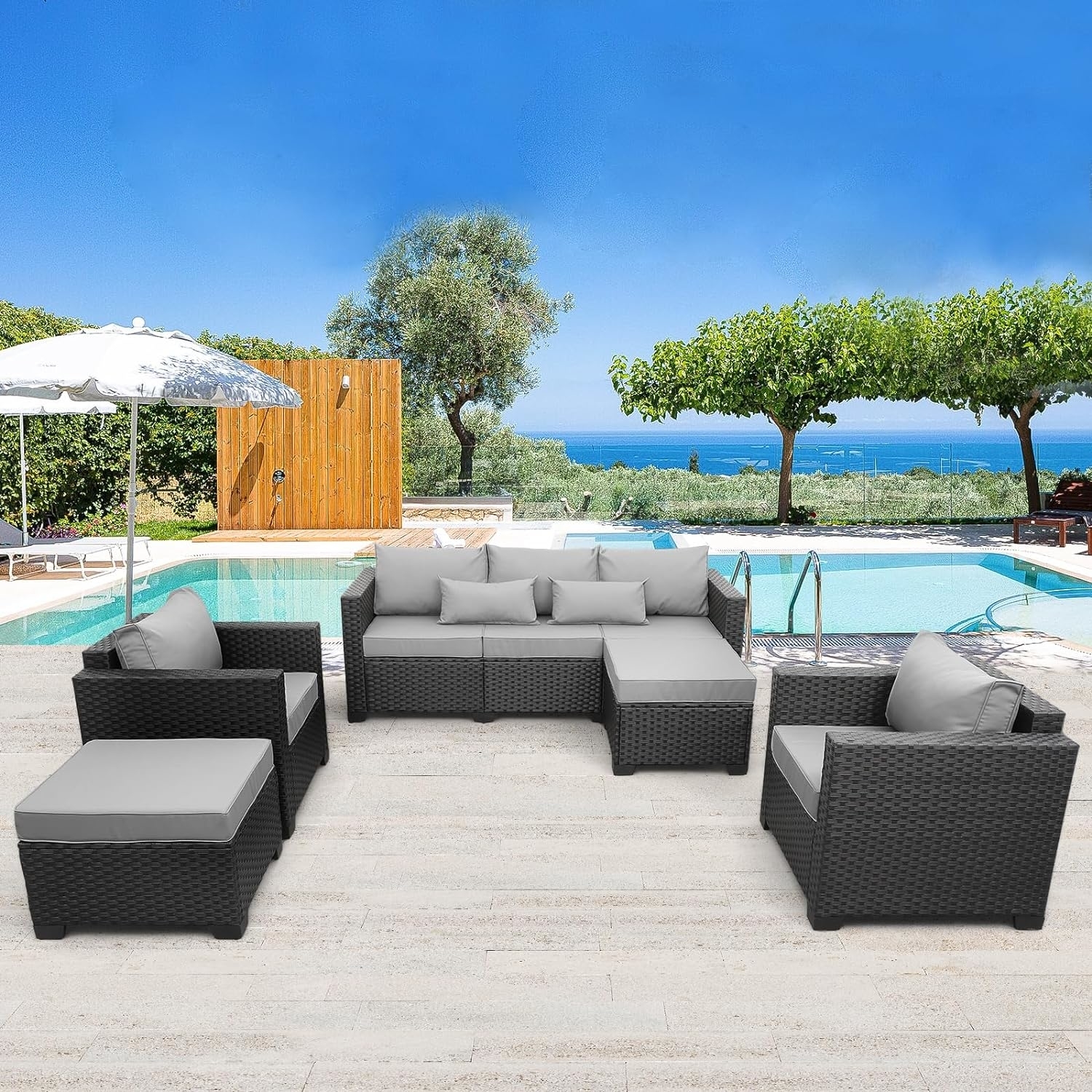 Outdoor patio furniture set with sofa, chairs, and ottoman by a pool, featuring a modern wicker design and neutral cushions