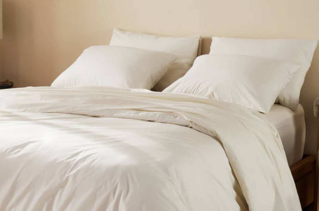 A neatly made bed with two large pillows and a soft, fluffy duvet, suggesting comfort and luxury bedding options for shoppers