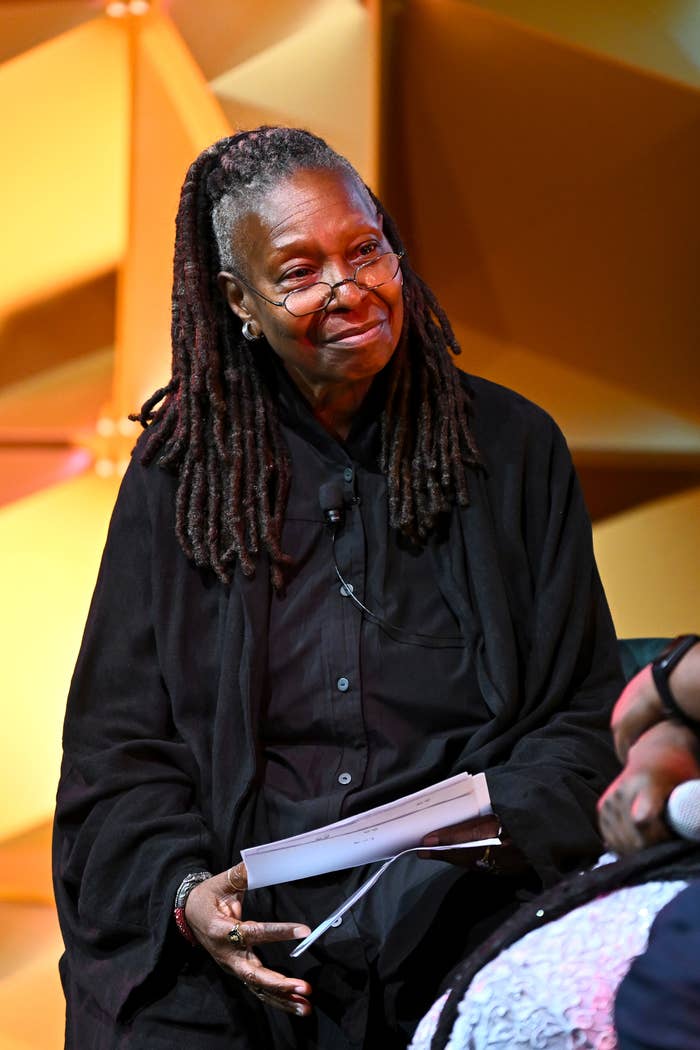 Whoopi Goldberg sitting on stage, engaged in conversation