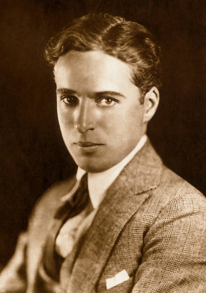 Person in vintage-style suit, from the year 1900, gazes at the camera with a neutral expression