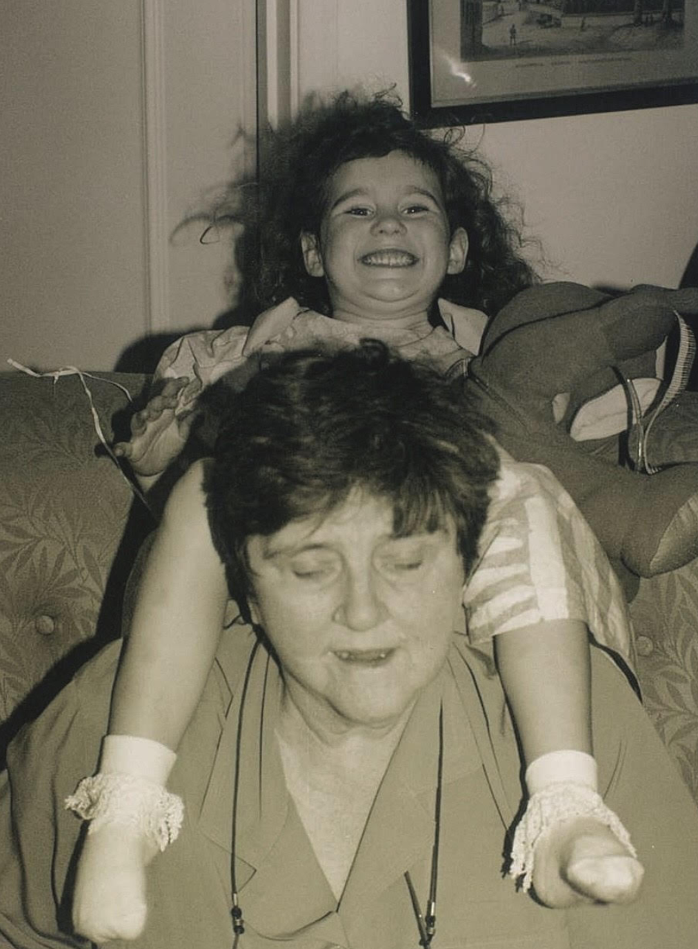 Christine sitter med en ung Christina på skuldrene, begge smiler