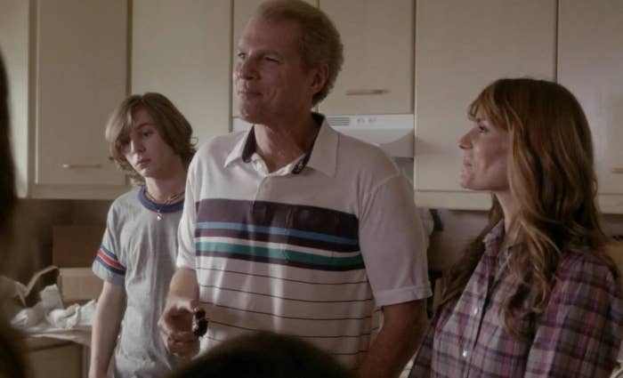 A family scene from a TV show, with a teenager and two adults in a kitchen, conveying a casual, everyday moment