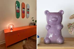 A room with a modern orange console, skateboards on the wall, and a large purple gummy bear ceramic decoration on a shelf
