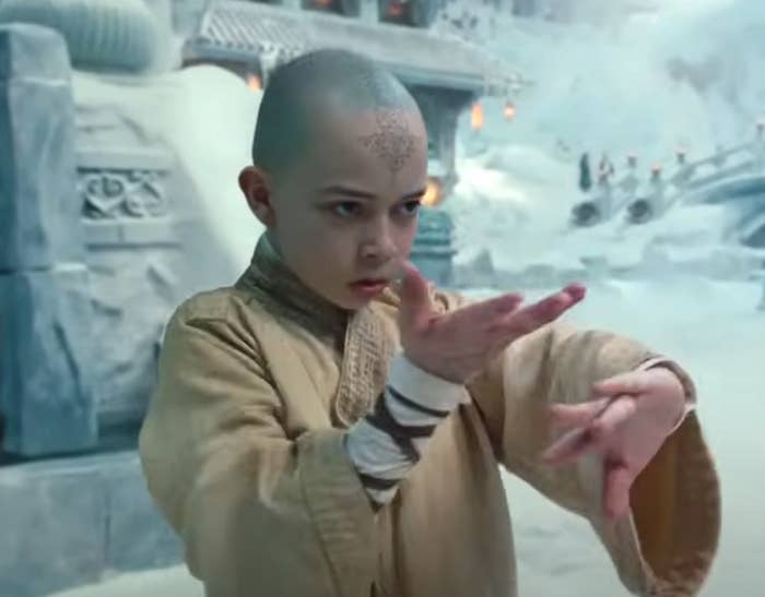 Person in a martial arts pose, wearing a robe, in a snowy ancient temple setting