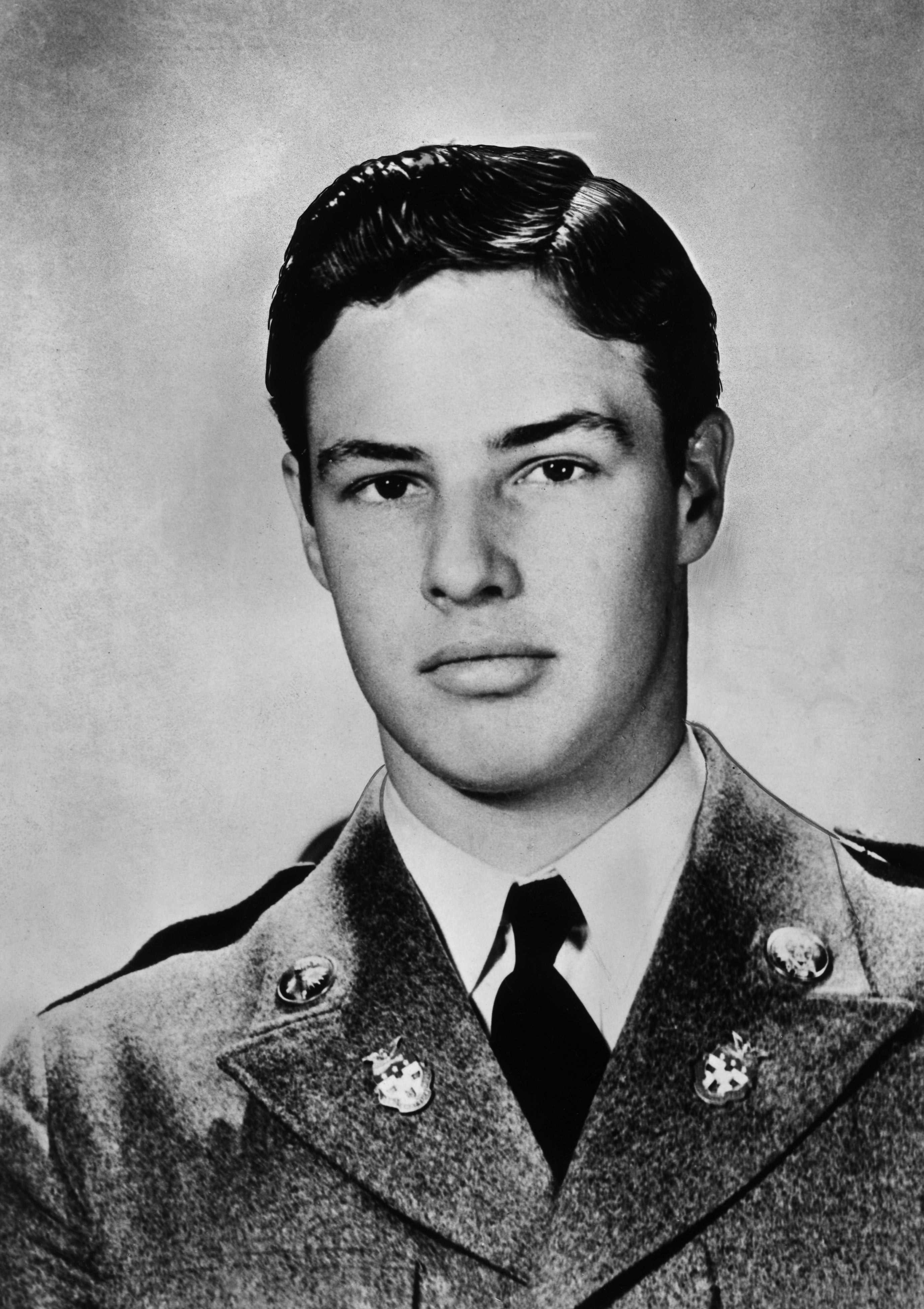 Young man in formal military uniform with a serious expression, looking directly at the camera in a classic portrait style