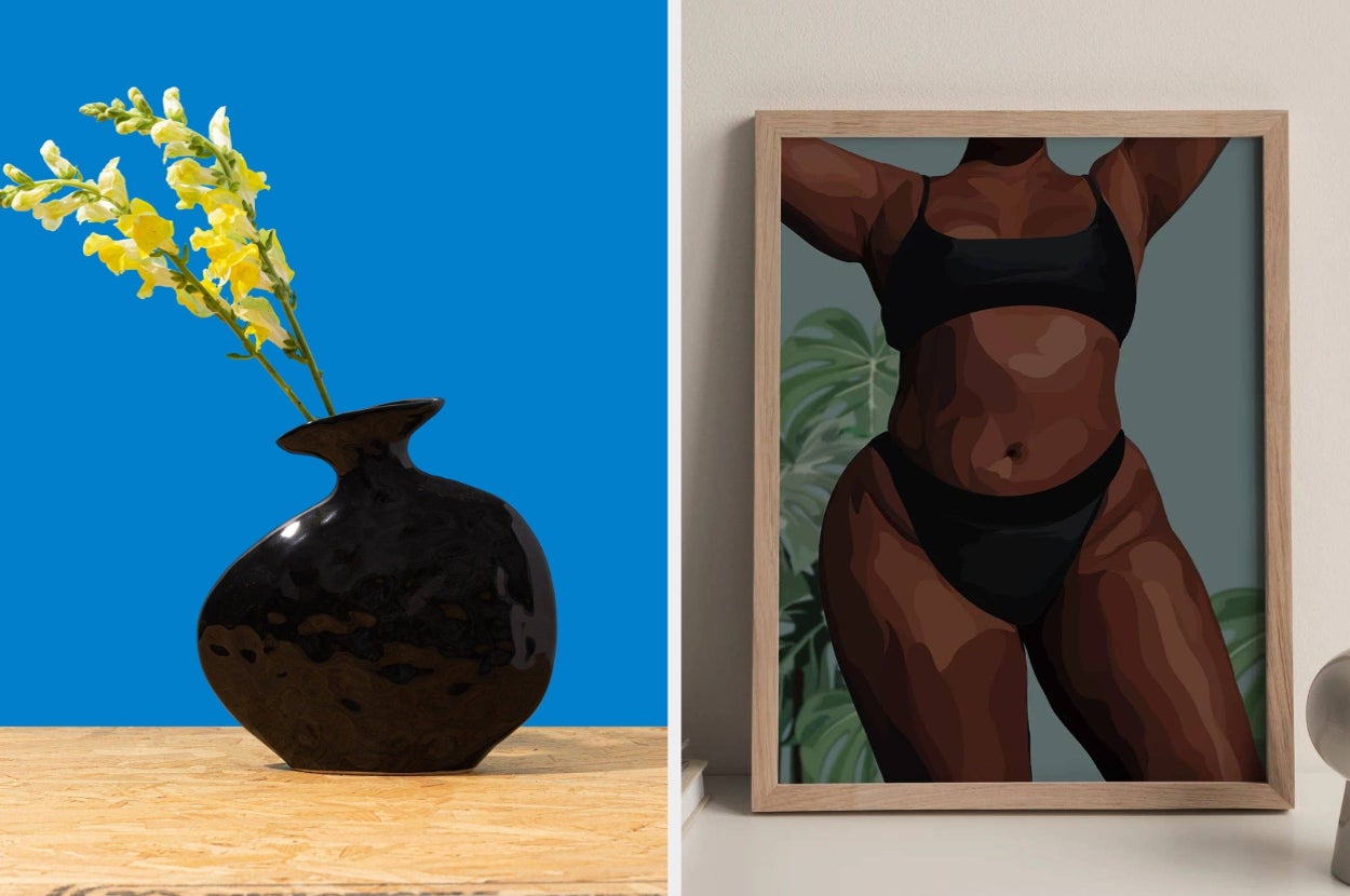 Black vase with yellow flowers on a wooden surface; framed art of a woman in a black outfit with foliage background