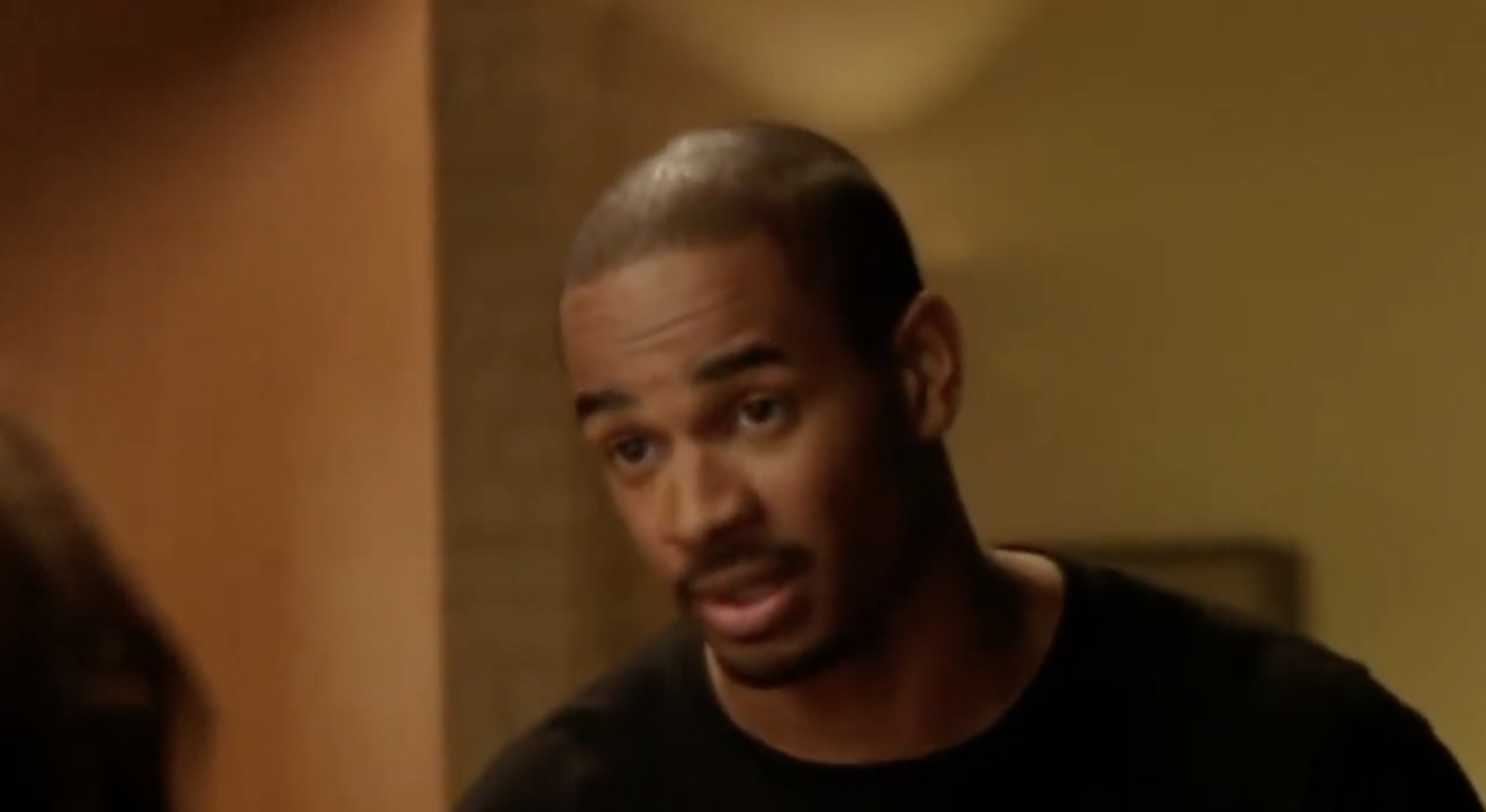 Person in a conversation, wearing a casual black shirt, background out of focus