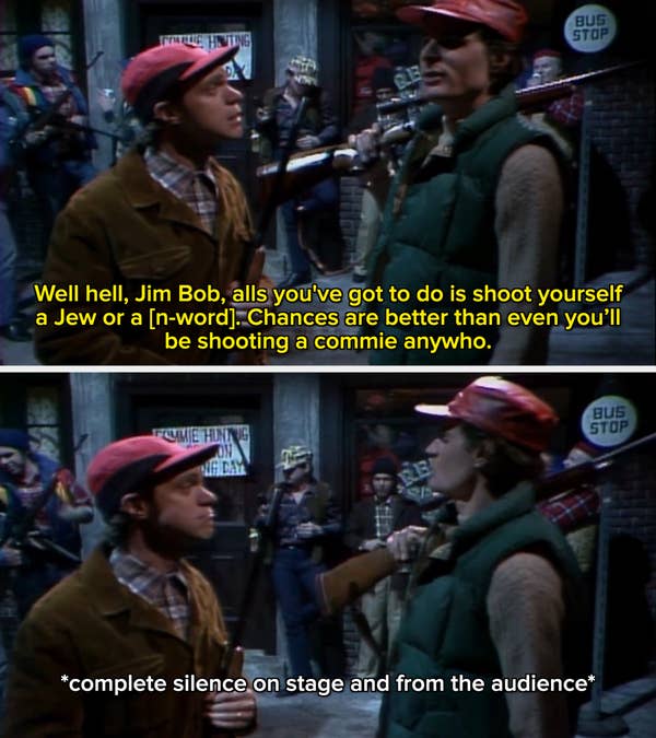 Scene of two people with rifles at a bus stop set, others in background; rugged, casual attire suggests a comedy or drama skit. 