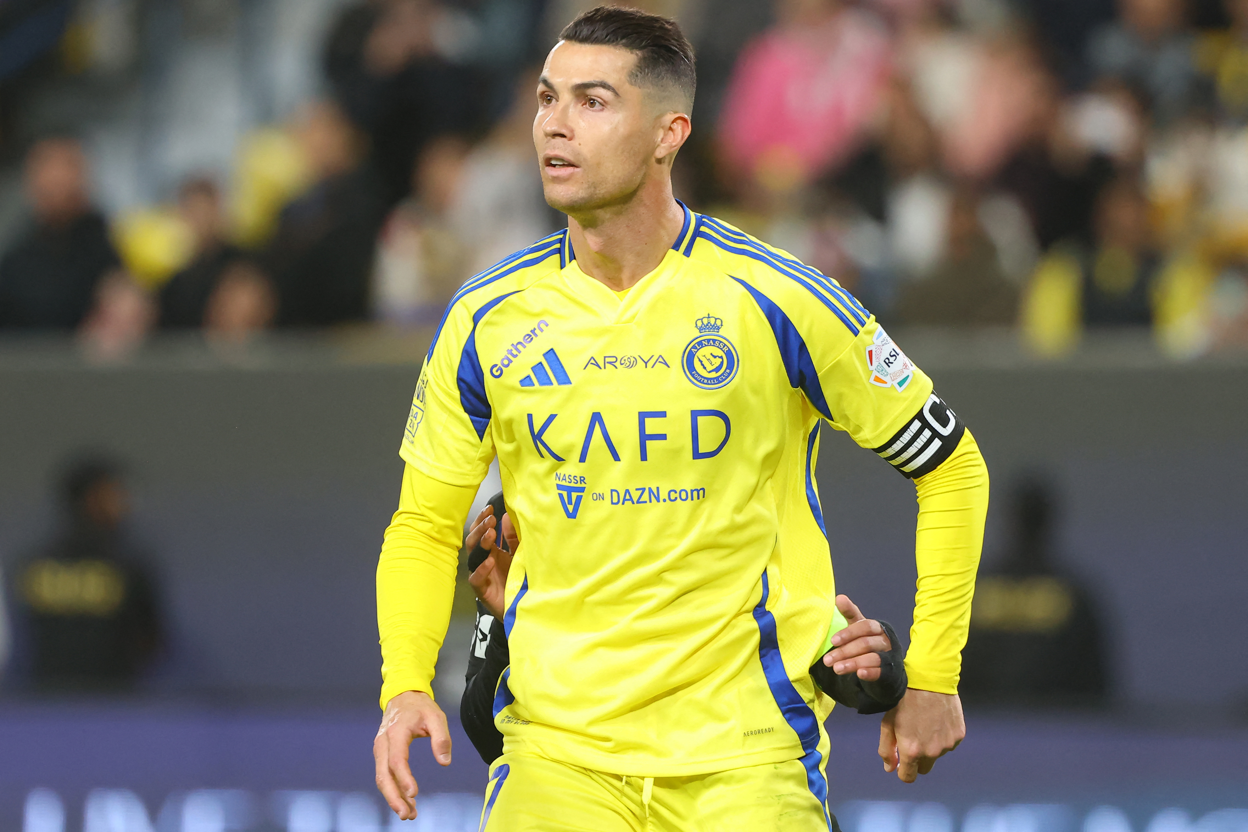 Ronaldo in a yellow and blue jersey with a captain's armband during a match.