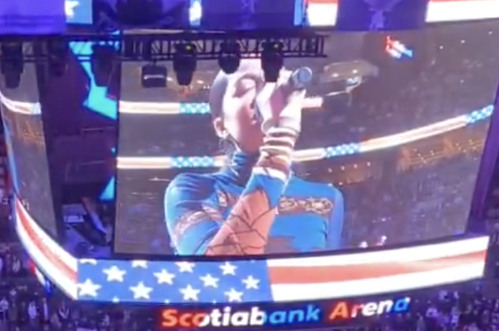 NBAの試合開始前に国歌を歌う歌手。コートには大きな星の模様が映し出されている。