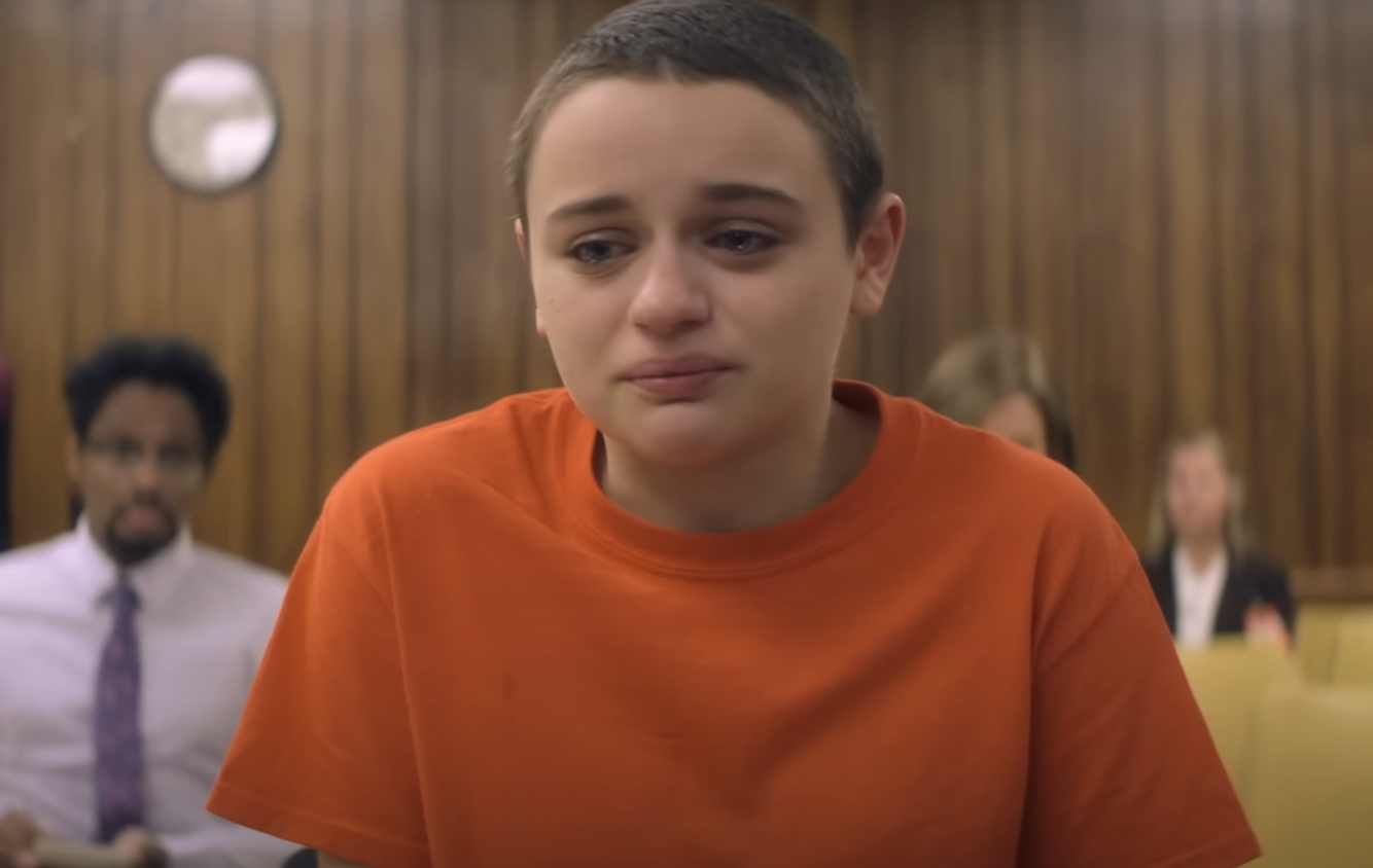 Joey King in character in a prison orange tshirt with a shaved head and a tearful expression