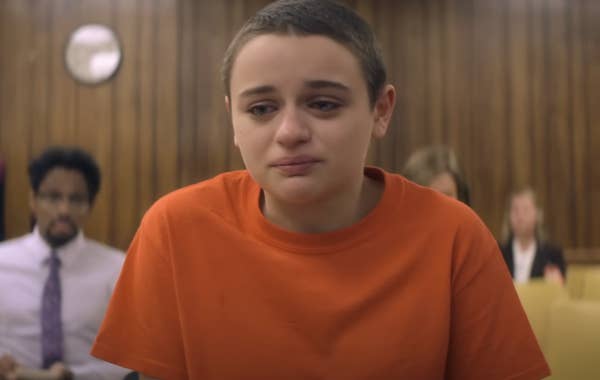 Joey King in character in a prison orange tshirt with a shaved head and a tearful expression