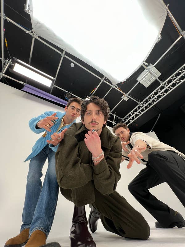 Nick, Milo, and Spencer pose dramatically on a set with studio lighting