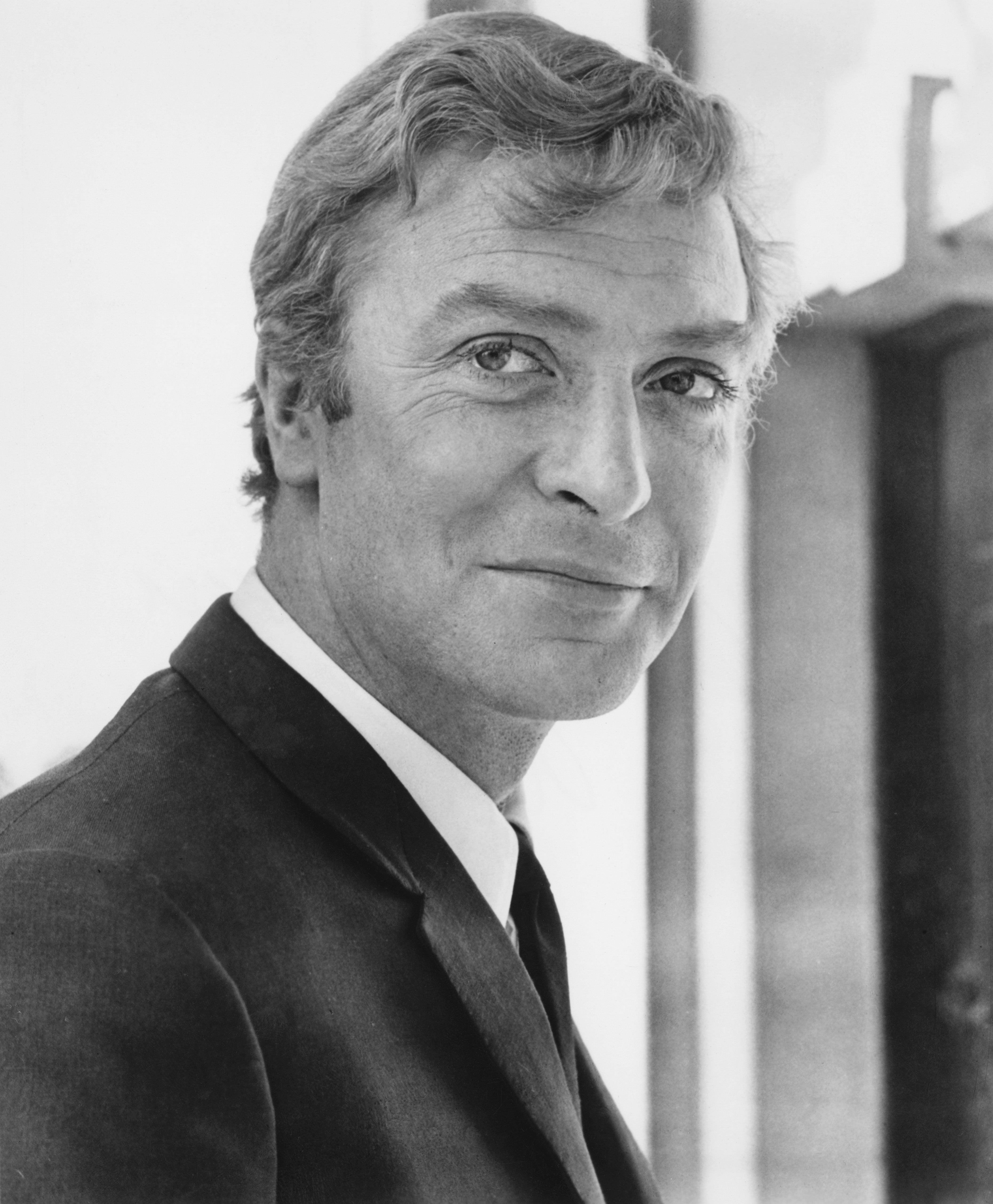 Person in a suit smiling, posing for a formal portrait