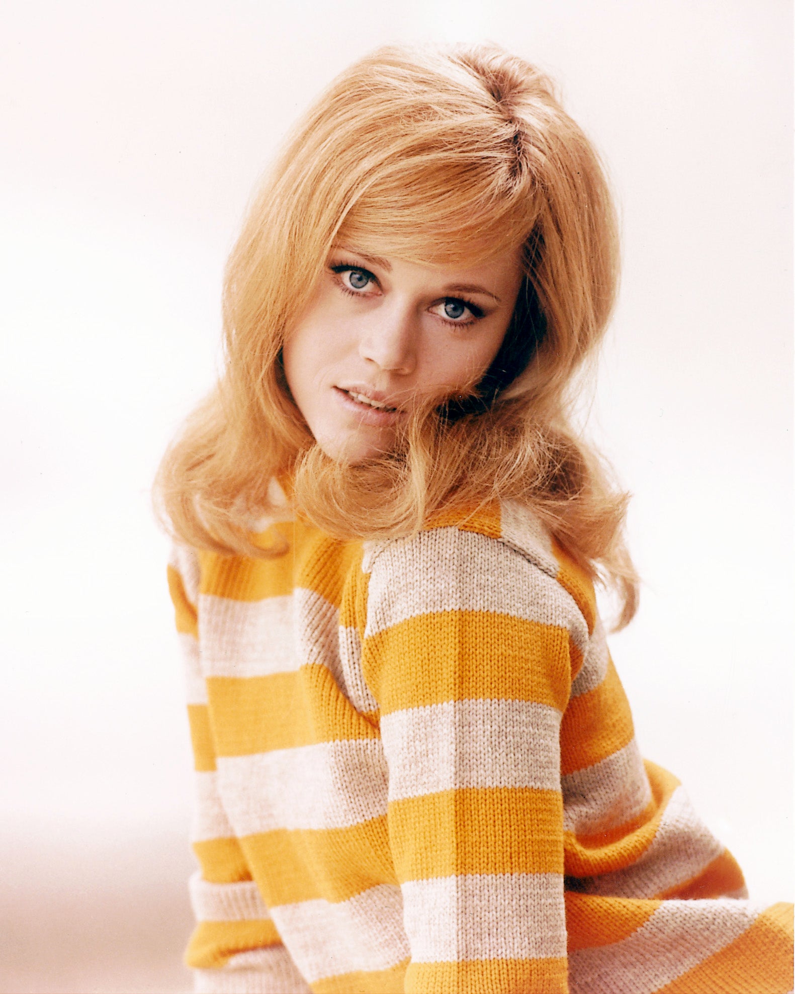 Person with long hair, wearing a striped sweater, looking at the camera