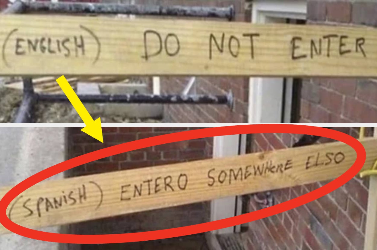 Two wooden planks with handwritten text: "Do Not Enter" and "Entero Somewhere Elso" for English and Spanish, respectively