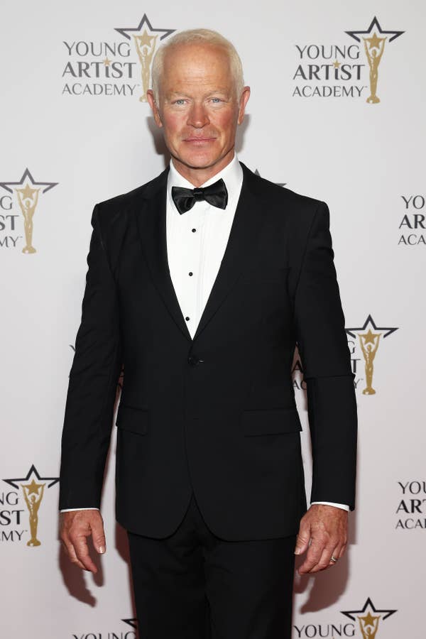 Person in a classic black tuxedo with a bow tie on the red carpet at the Young Artist Academy event