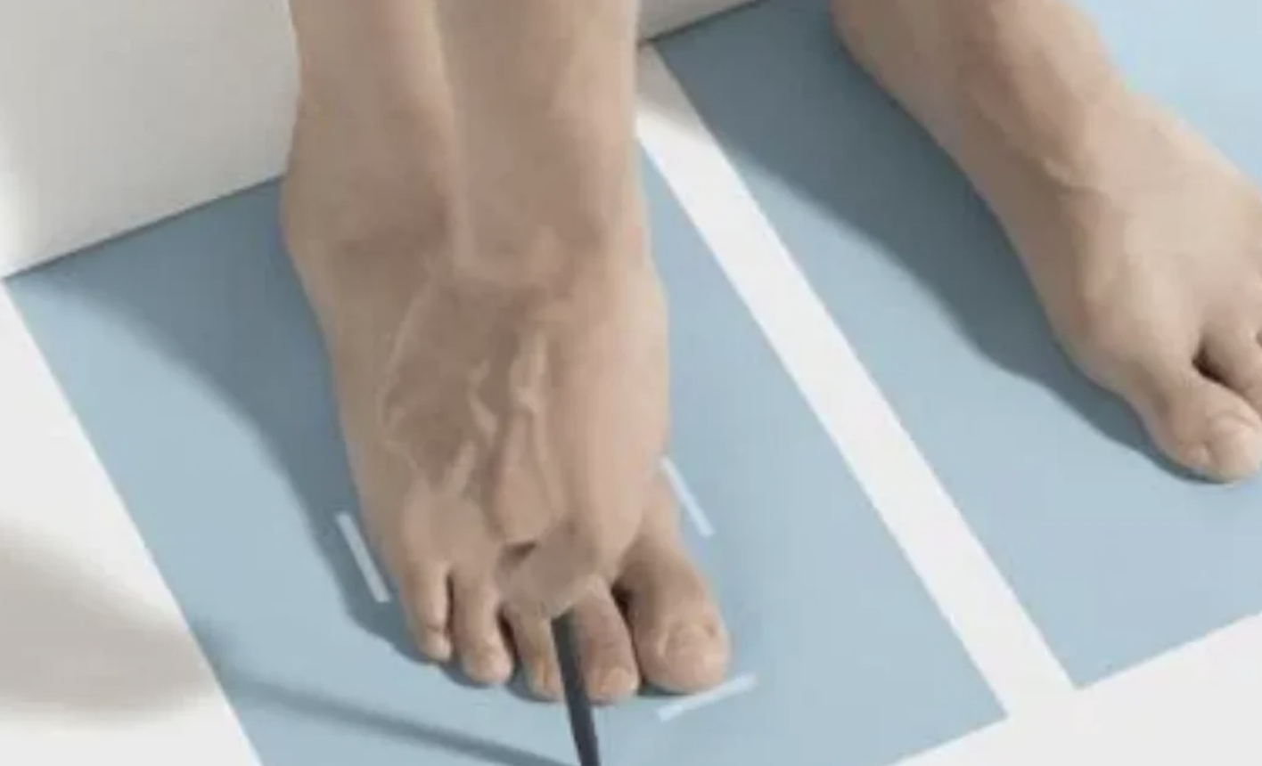 A ft  being measured with a integer  tool, positioned connected  marked paper, apt  for sizing oregon  fitting purposes