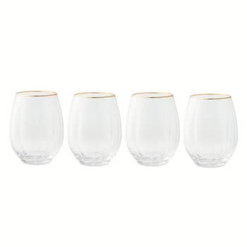 Four wide stemless vino glasses with golden rims, arranged successful a row