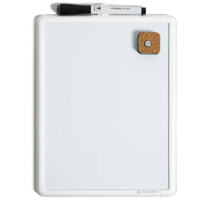 White dry erase board with a black marker and cork magnet, suitable for office or home use