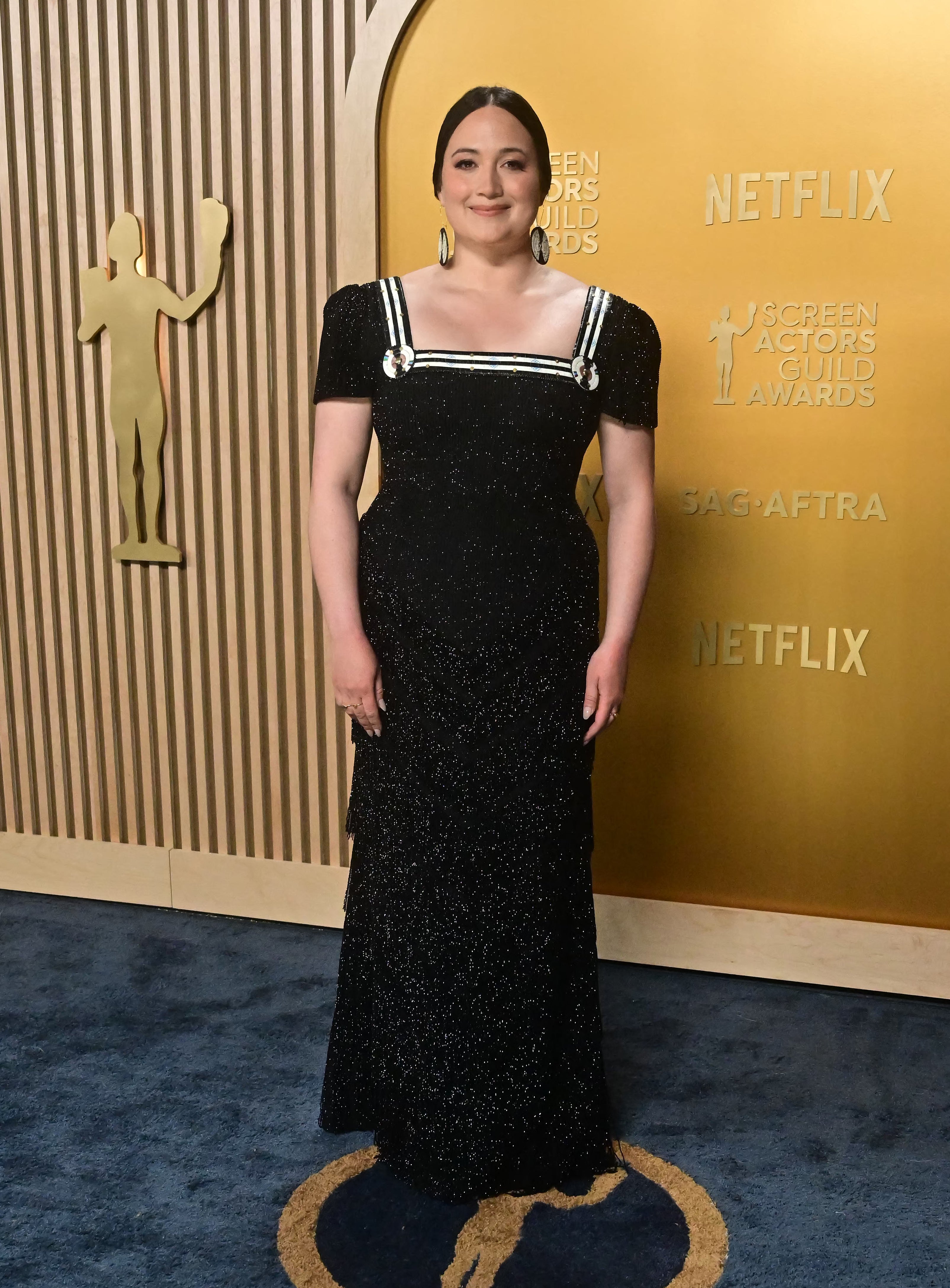 Person in elegant black gown with white accents on the red carpet at the Screen Actors Guild Awards