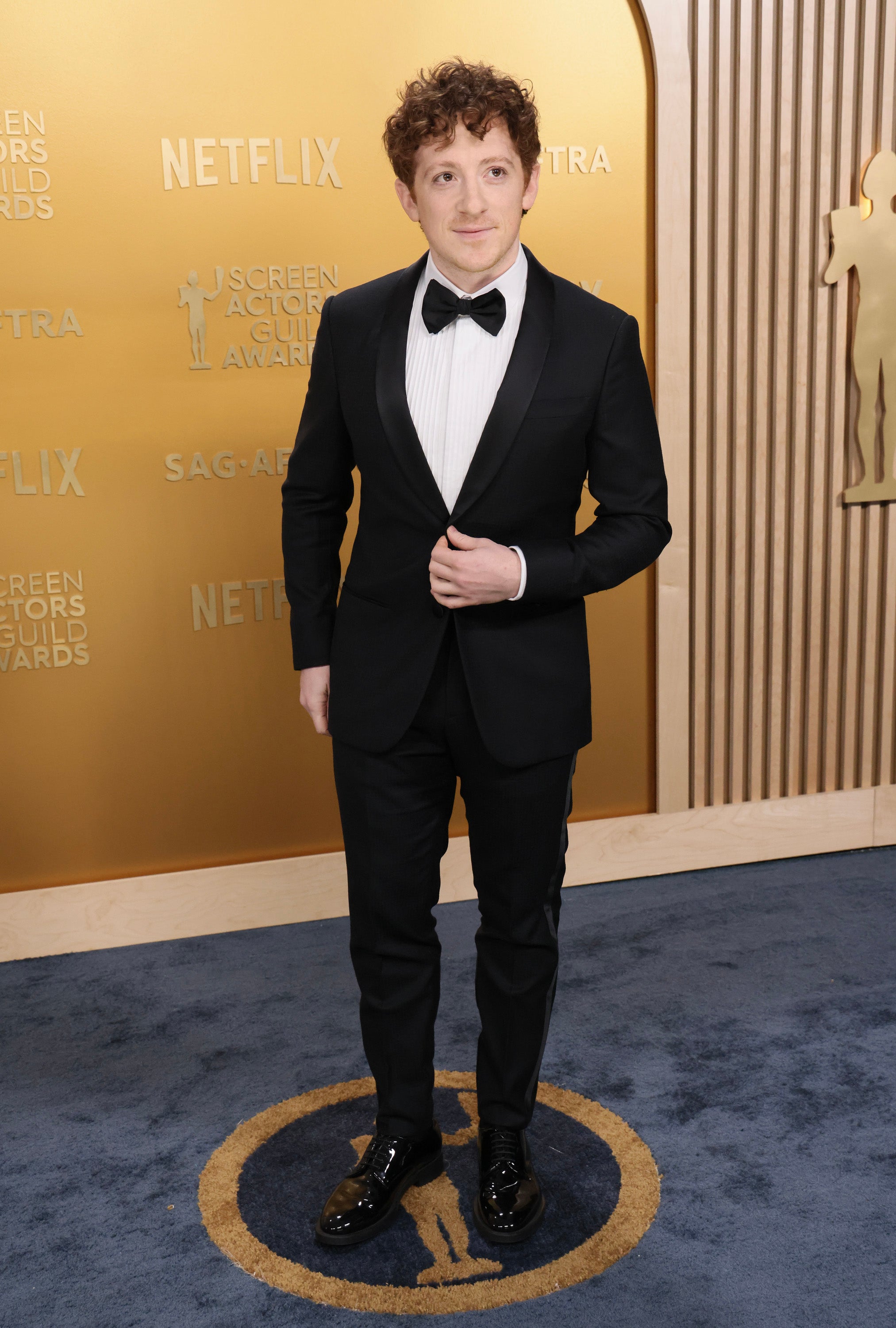 Person in a tuxedo on a red carpet at the Screen Actors Guild Awards event