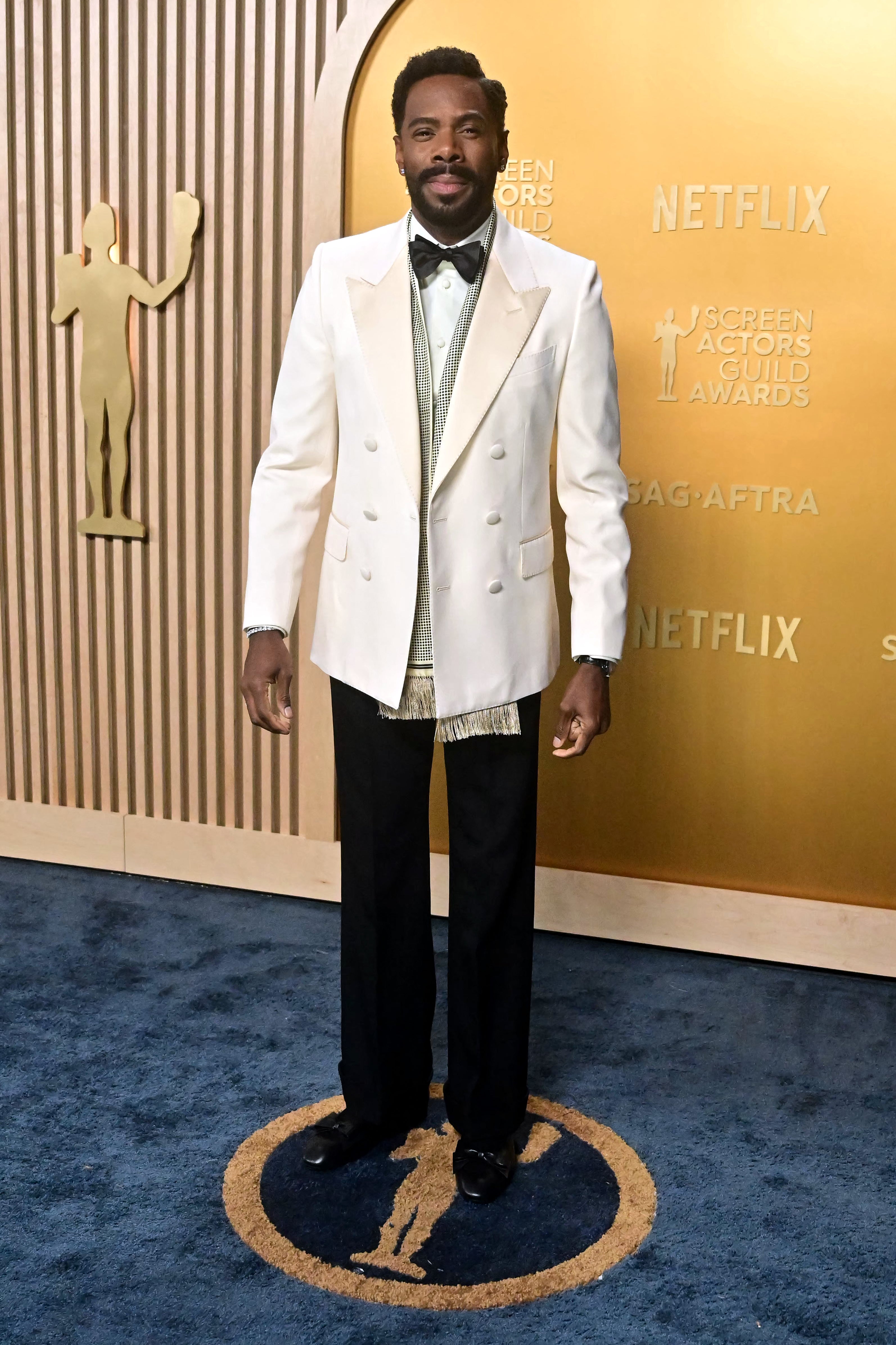 Person in a white double-breasted suit with a bow tie at the SAG Awards red carpet