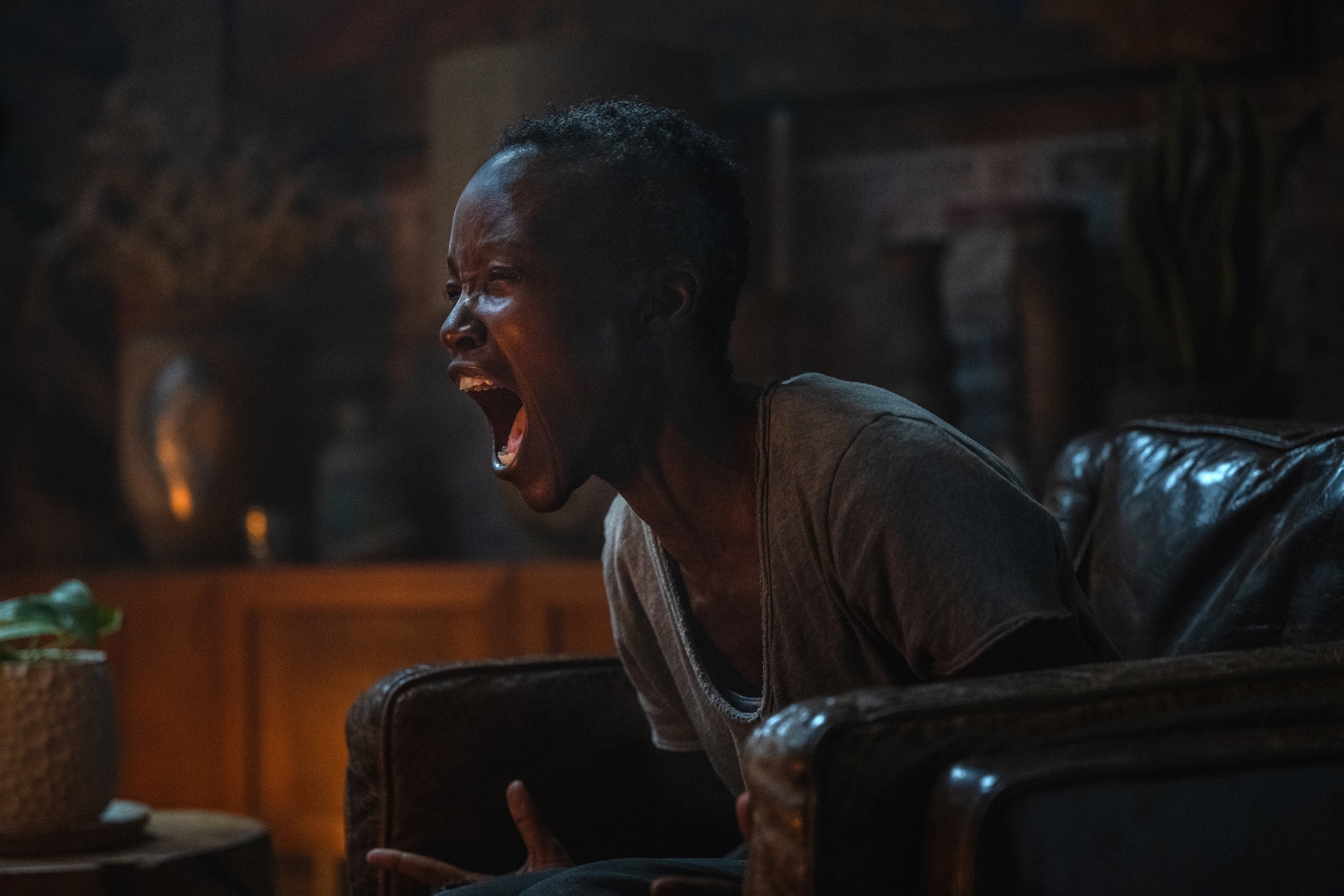 Lupita Nyong'o looks pained as she screams on a chair