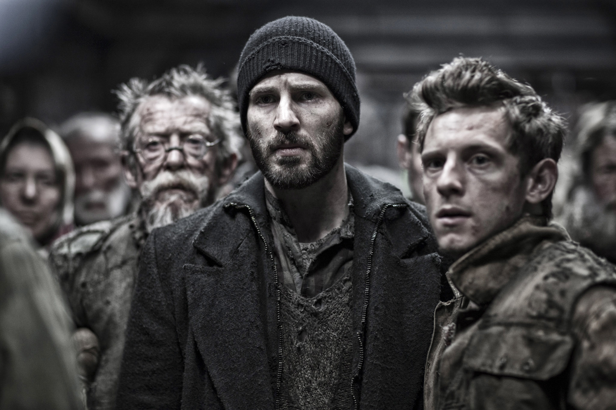 Actors in a gritty, dystopian scene look determined, including Chris Evans and Jamie Bell