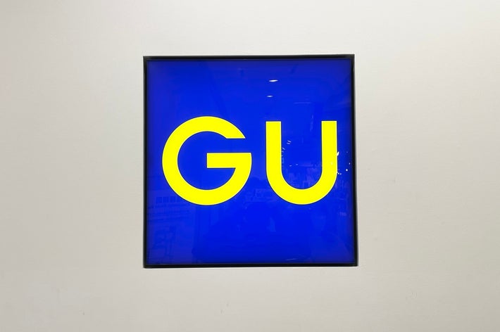 Sign with large yellow &ldquo;GU&rdquo; letters on a blue background, centered in the image