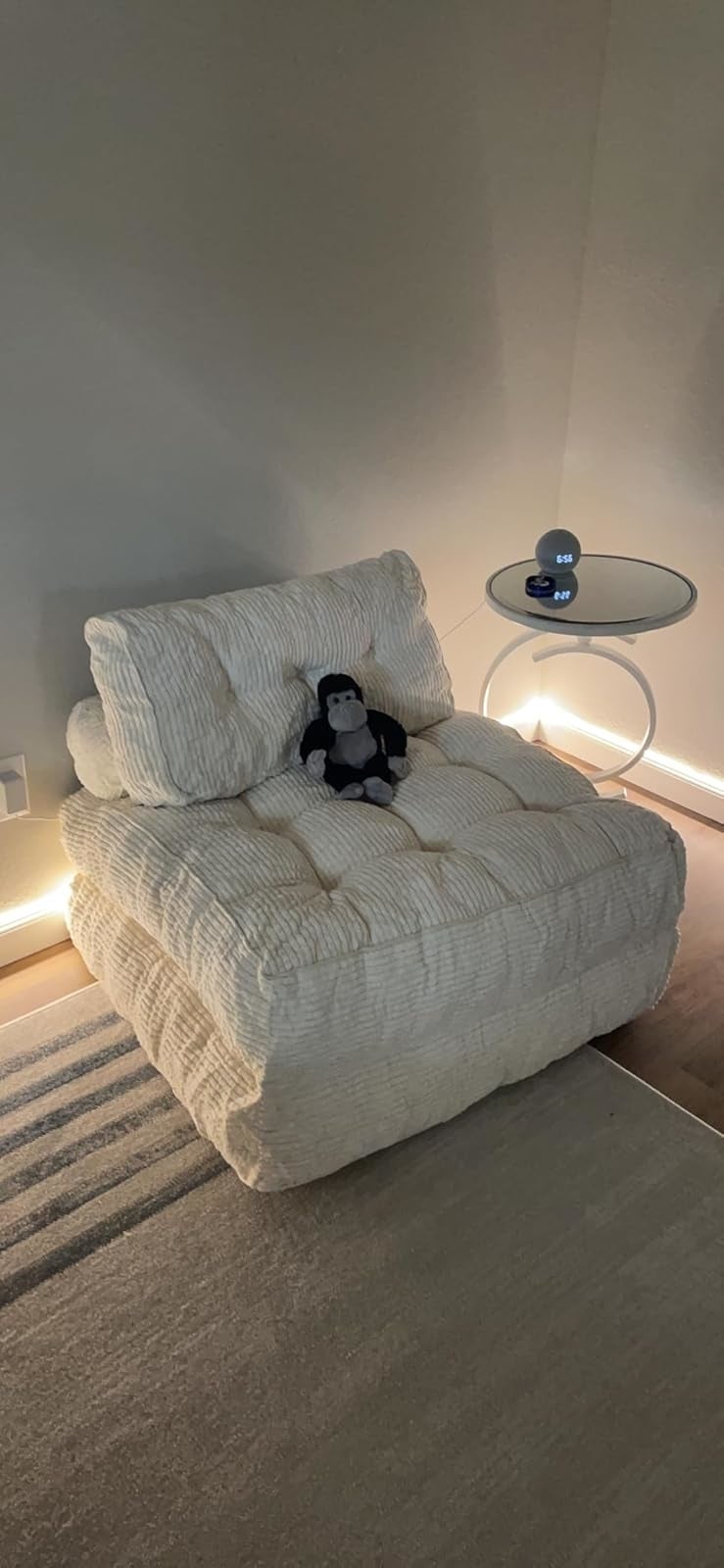 Cozy plush seat  with a artifact  penguin beside a sleek circular  array  featuring a astute  speaker, acceptable   successful  a warmly lit room. Ideal for relaxation