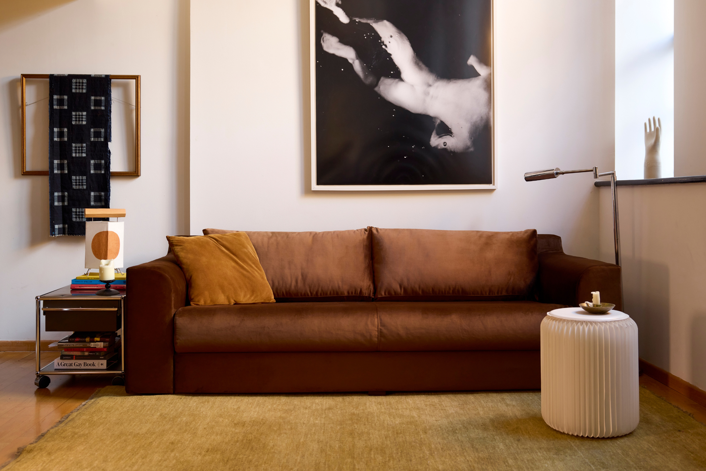 A modern living room with a brown sofa, a side table, and a large abstract art piece above, highlighting contemporary home decor