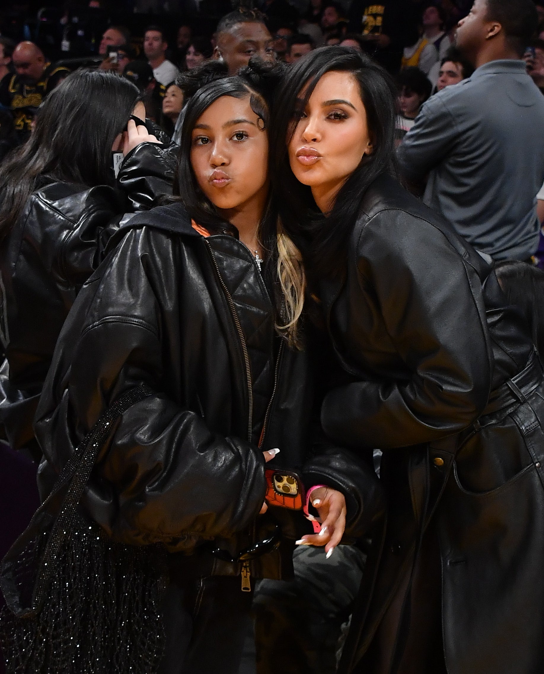 Kim Kardashian and North West pose together at a basketball game